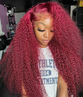 Model wearing a long burgundy water wave wig with voluminous curls, a side part and sculpted baby hairs.