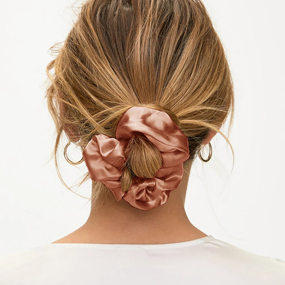 Back view of a rose gold scrunchie securing blonde hair in a low bun.